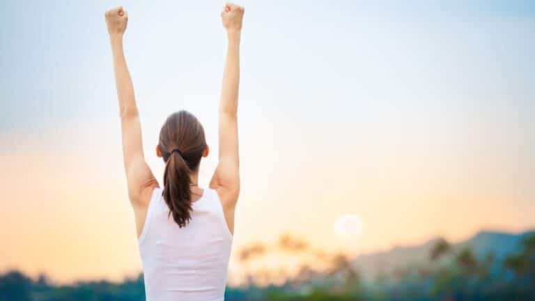 Woman raising her arms in the air in achievement