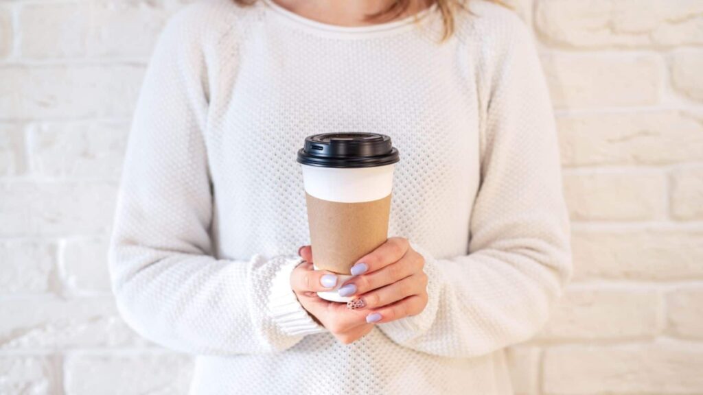 Woman holding free coffee cup