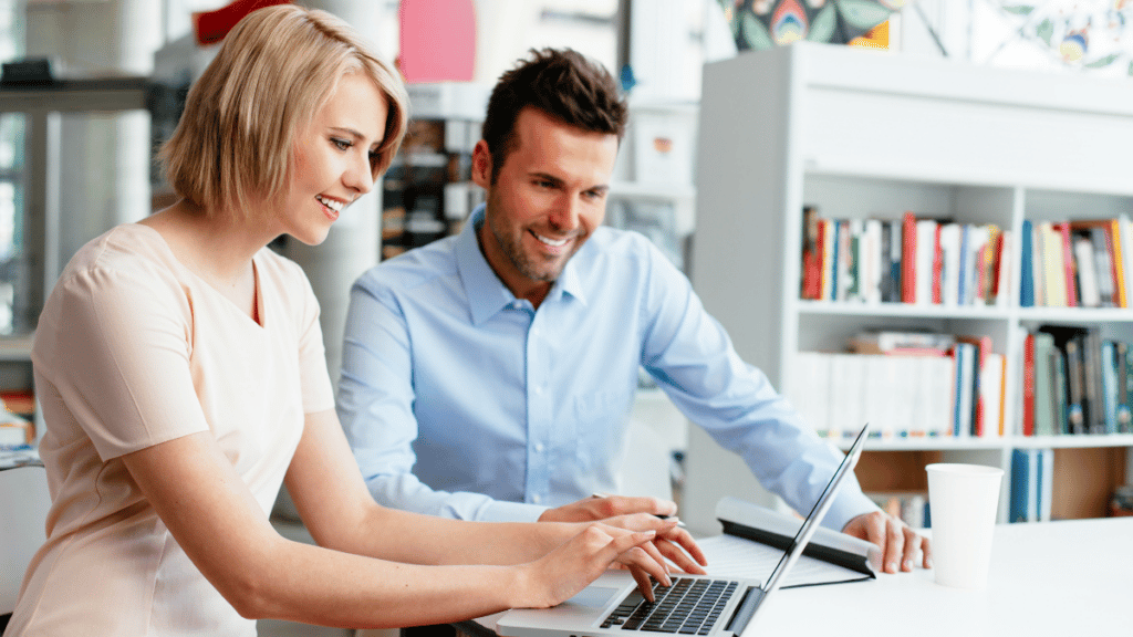Couple looking at a laptop looking happy