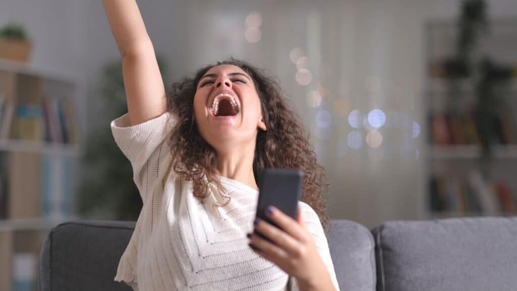 Woman holding her phone and being excited