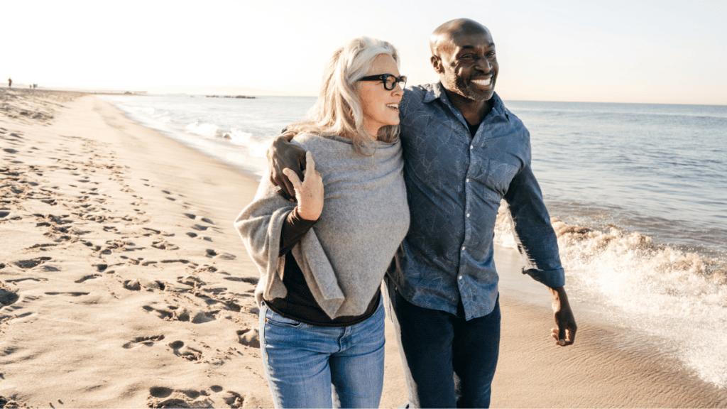 Couple walking on the beach experiencing financial freedom
