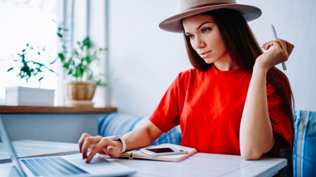 Woman in hat working on laptop