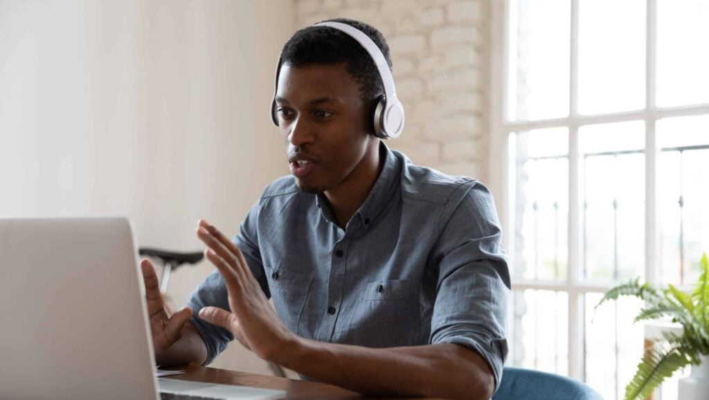 Man sitting at a laptop with headphones on