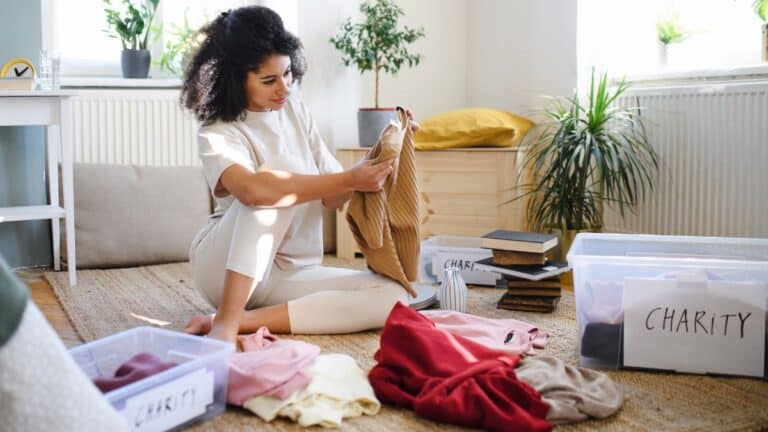 Woman sitting on the ground decluttering her room