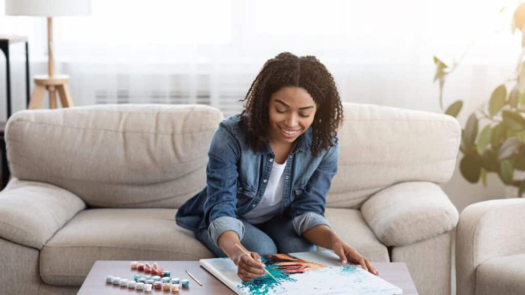 Young woman painting in her living room