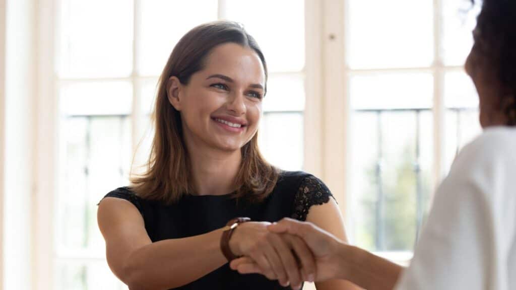 Woman shaking her co-workers hand