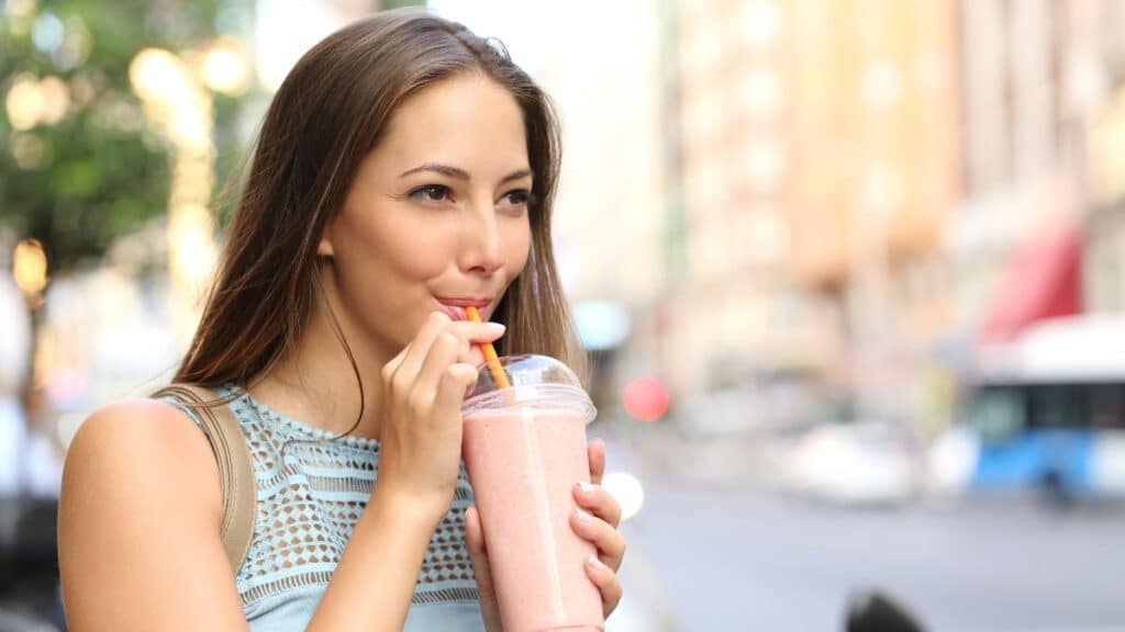 Woman outside drinking a milkshake