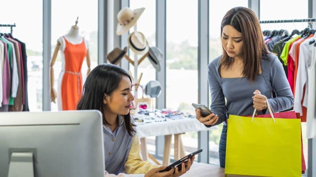 Cashier checking out a customer looking annoyed