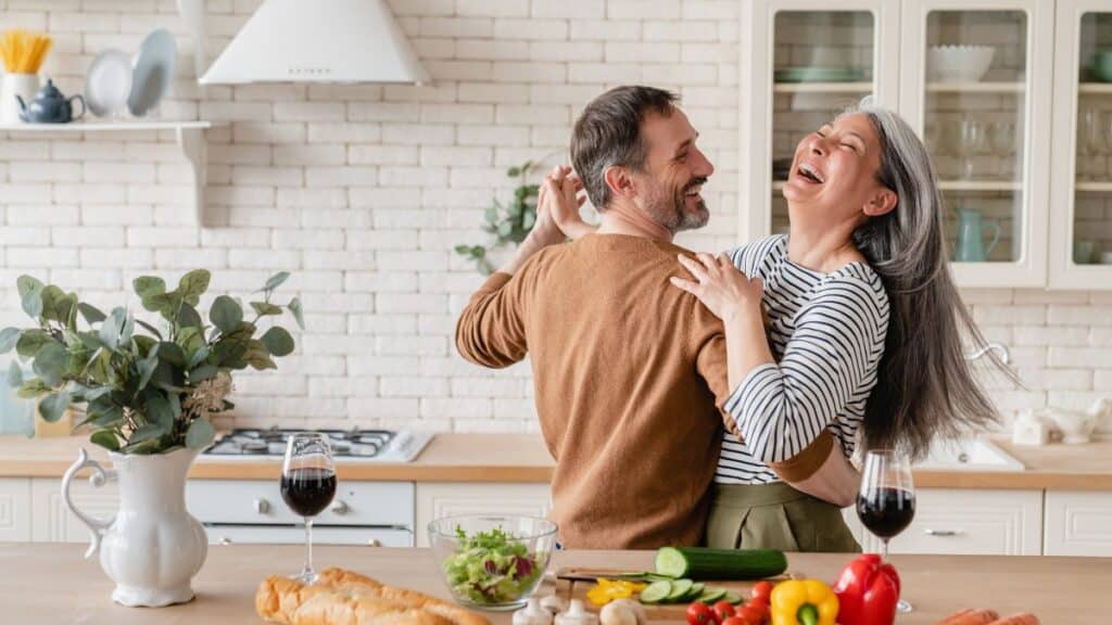 Middle-aged couple dancing in the kitchen