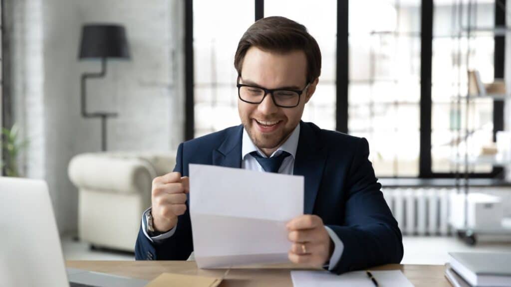 Man reading work letter and looking excited