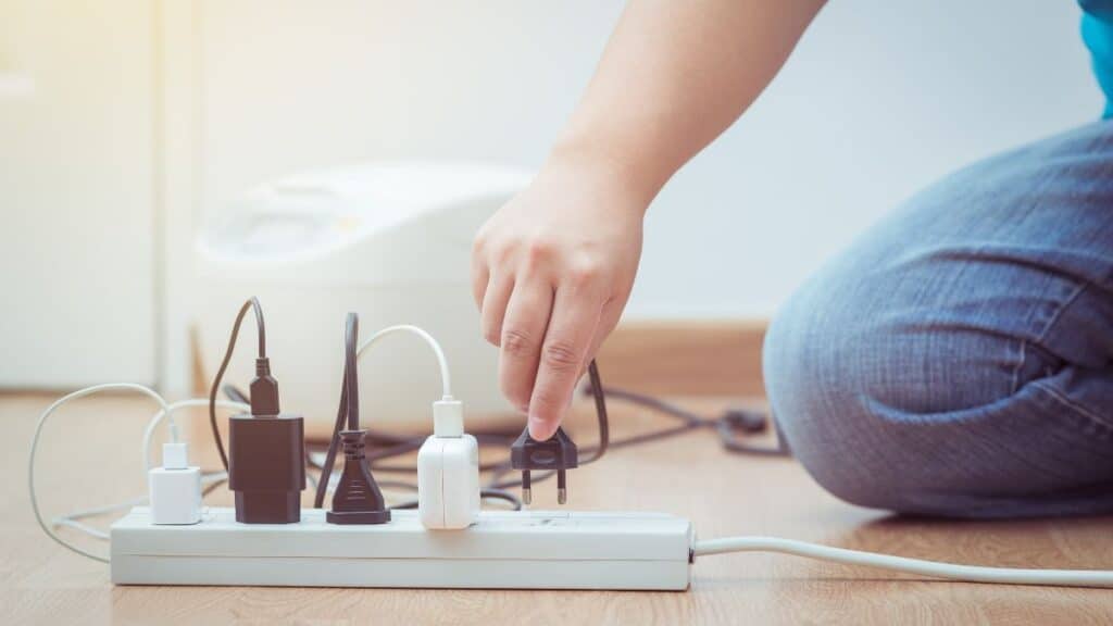 Man plugging a plug into a surge protector