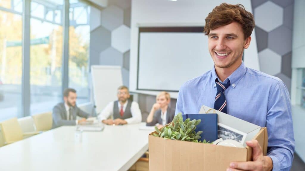 Man walking out of his job with a box filled with his belongings