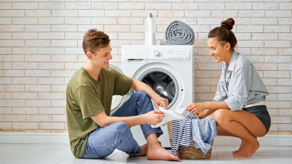 Couple sitting on the floor doing laundry together
