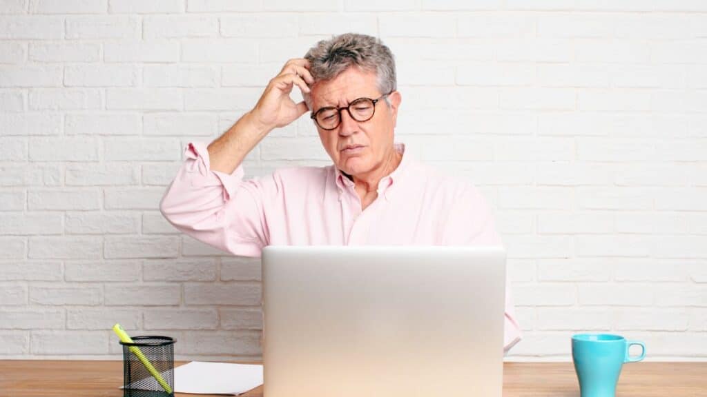 Older man looking confused while on his laptop