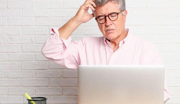 Older man looking confused while on his laptop