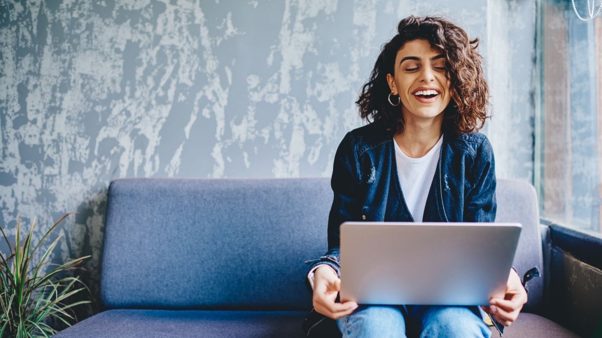 Happy millennial woman working on her laptop