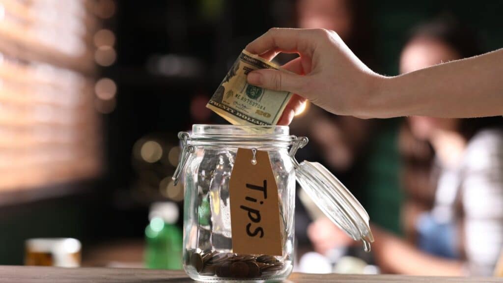 Person putting money in a tip jar