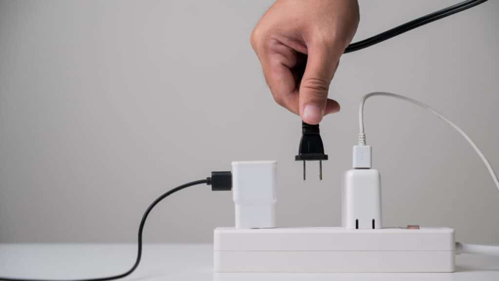 Person plugging a cord into a plug