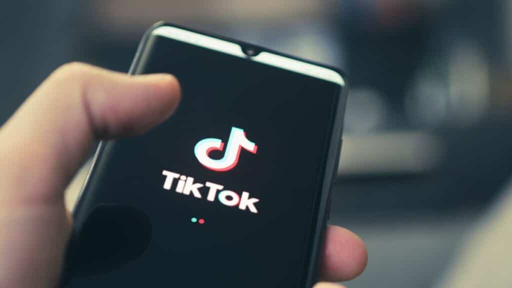 Person holding a phone with TikTok on the screen