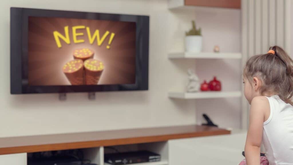 Little girl watching a commercial on TV