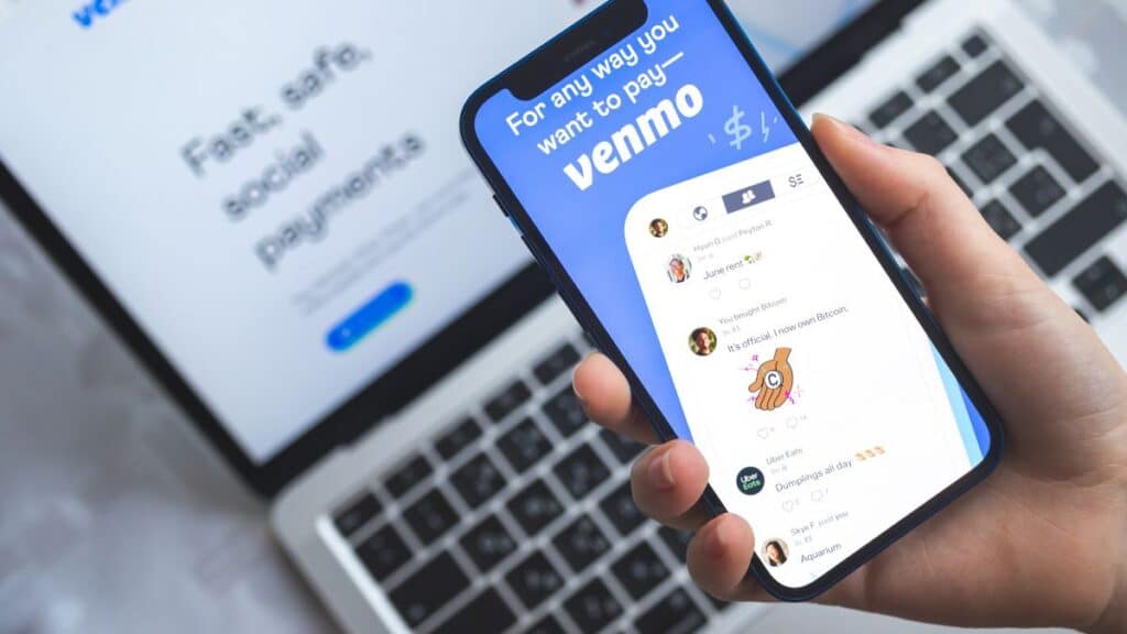 Person looking at Venmo on phone and laptop