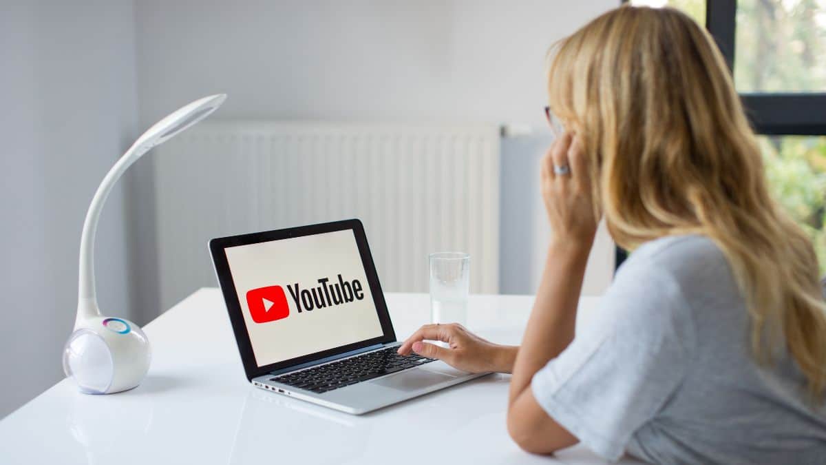 A woman is watching YouTube on her laptop