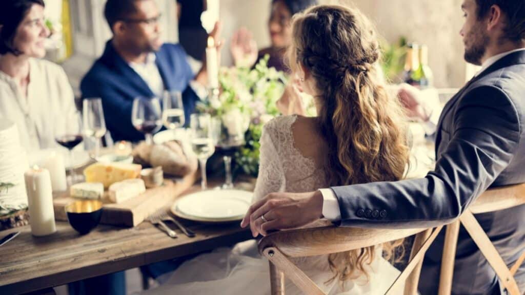 Adults sitting at a wedding reception with bride and groom