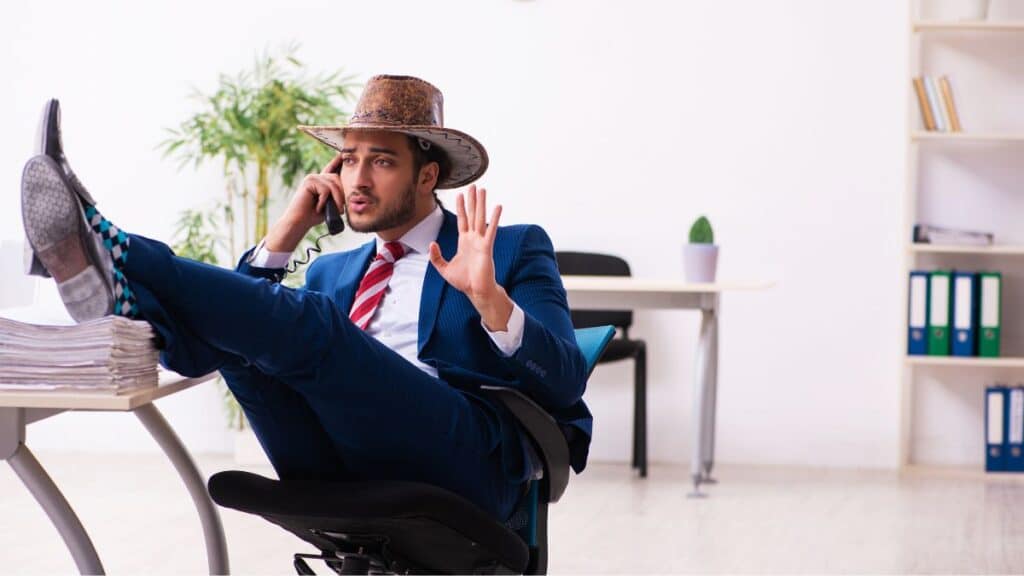 Man in a cowboy hat with his feet up on his desk
