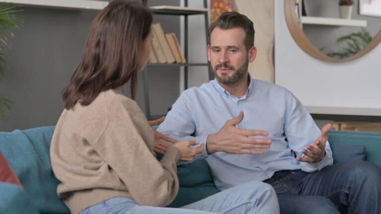 Couple sitting on couch arguing