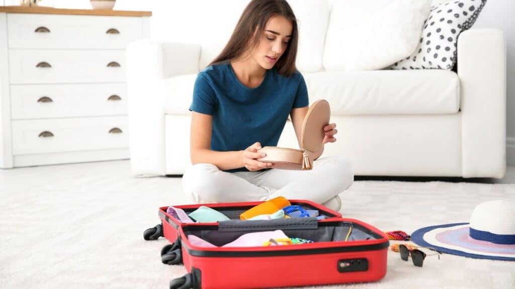 Young woman packing a suitcase