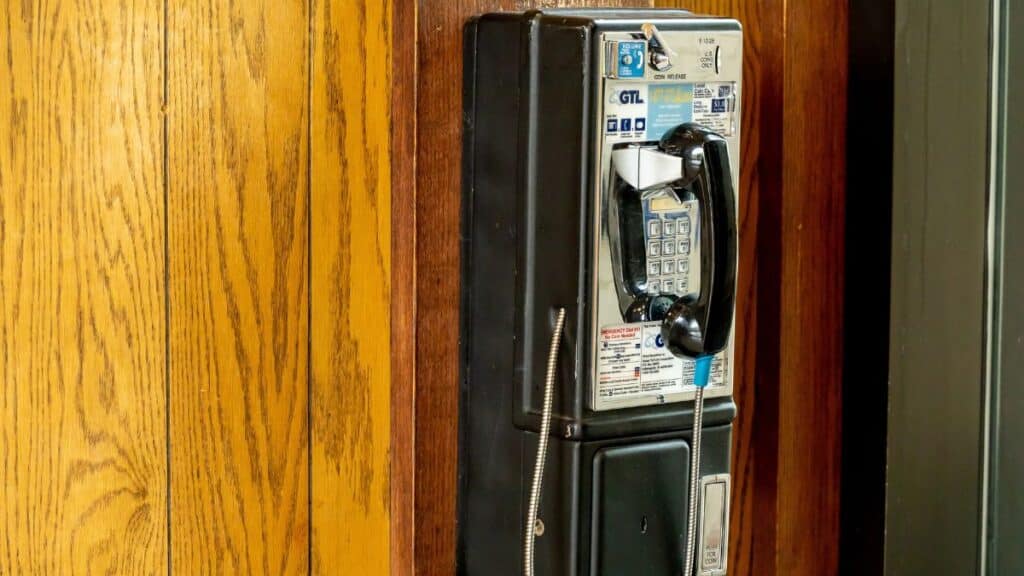 Old school pay phone on paneled wall