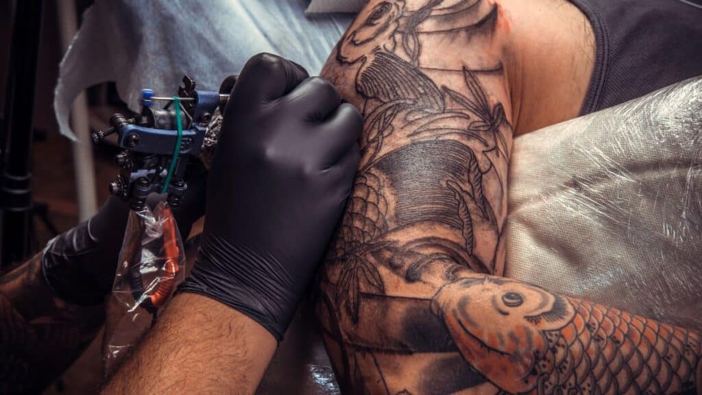 Someone giving someone a tattoo
