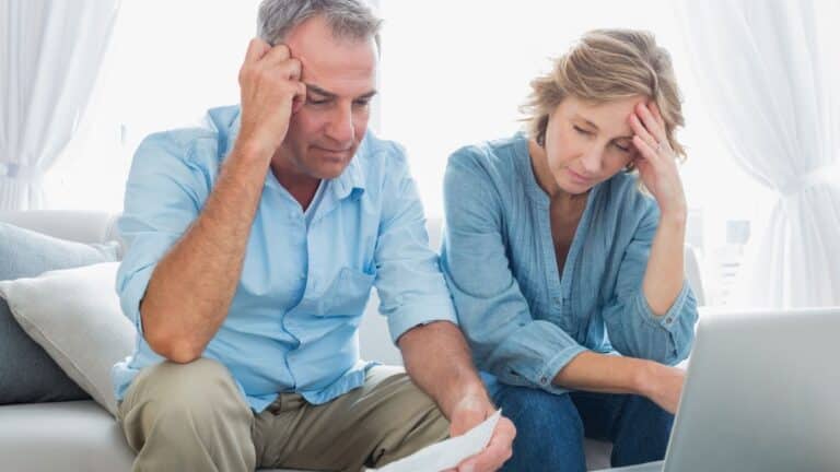 Middle-aged couple looking at papers and looking worried