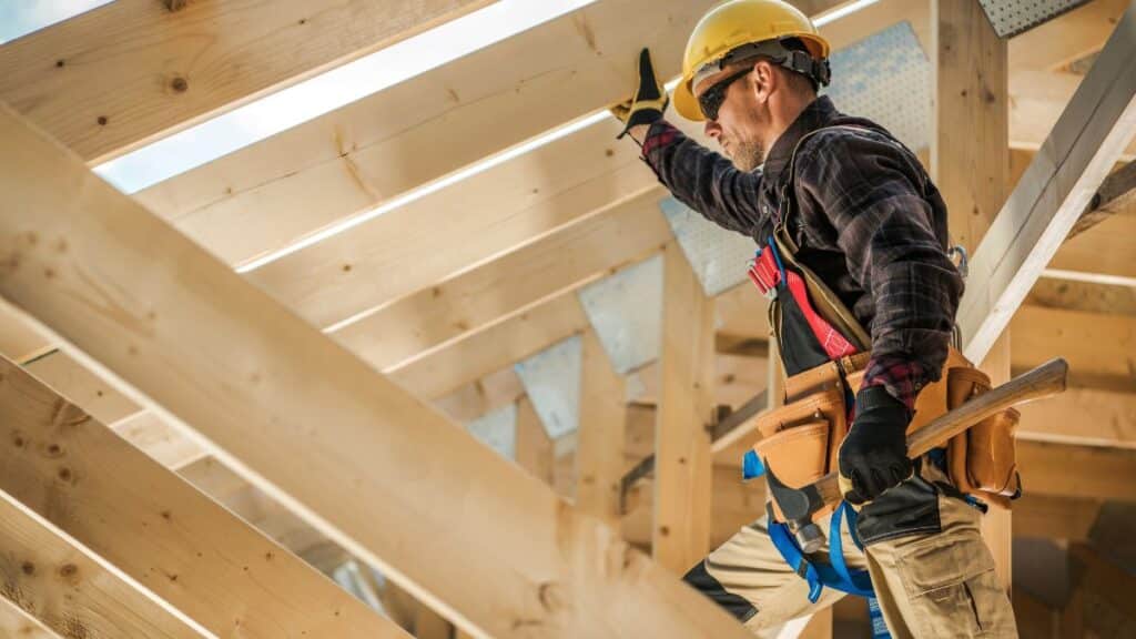 Man working on framing a house