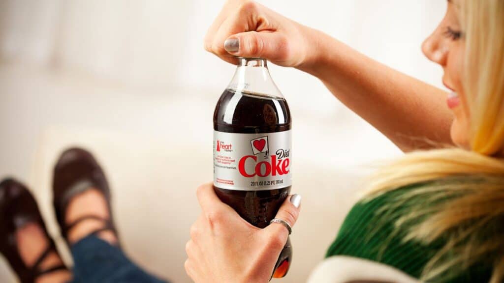 Woman opening a bottle of Diet Coke