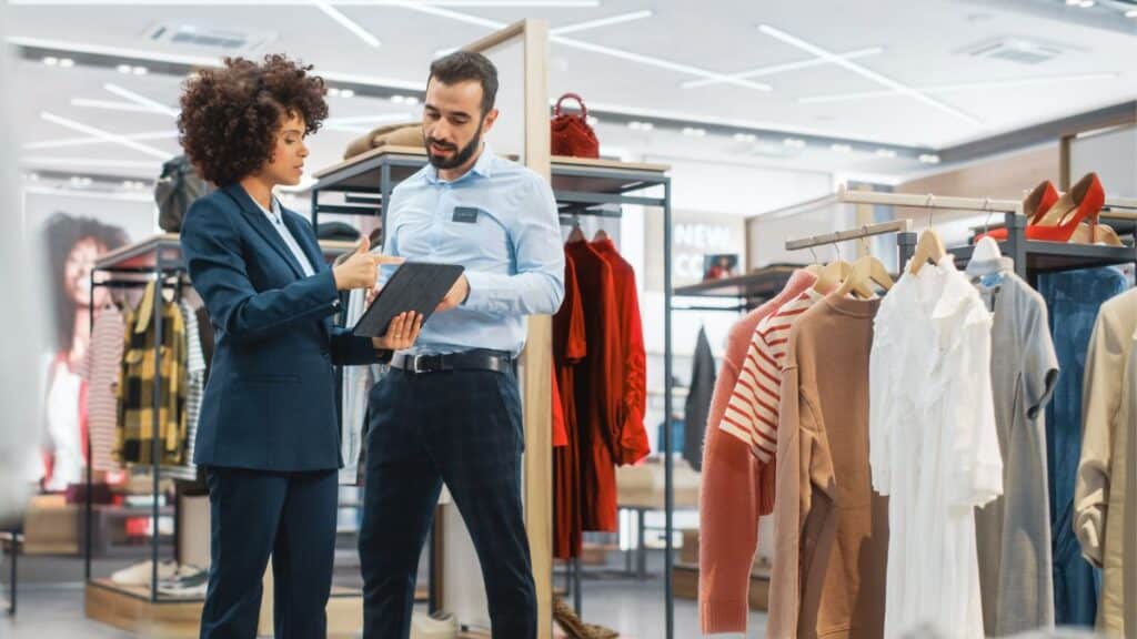 Retail manager speaking with an employee in a clothing store