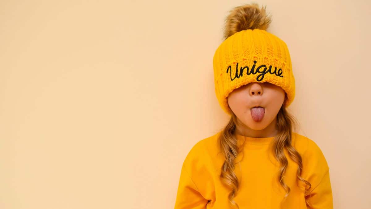 Cute little girl wearing a hat and sticking her tongue out