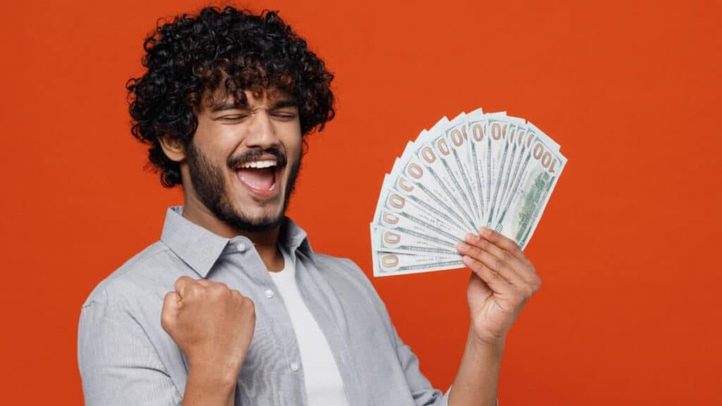 Excited man holding cash and looking excited