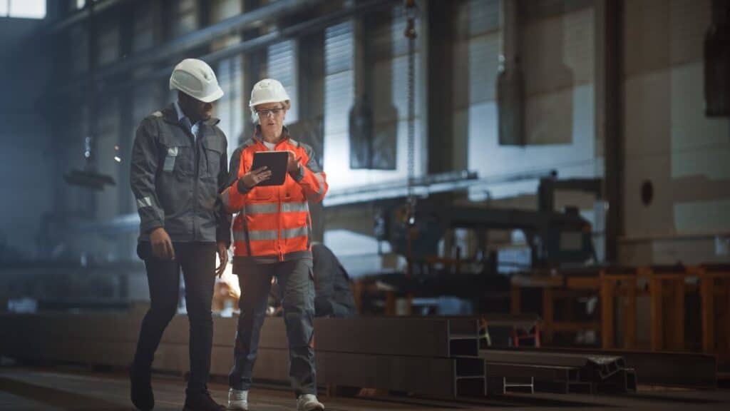 Workers speaking in a factory with hardhats