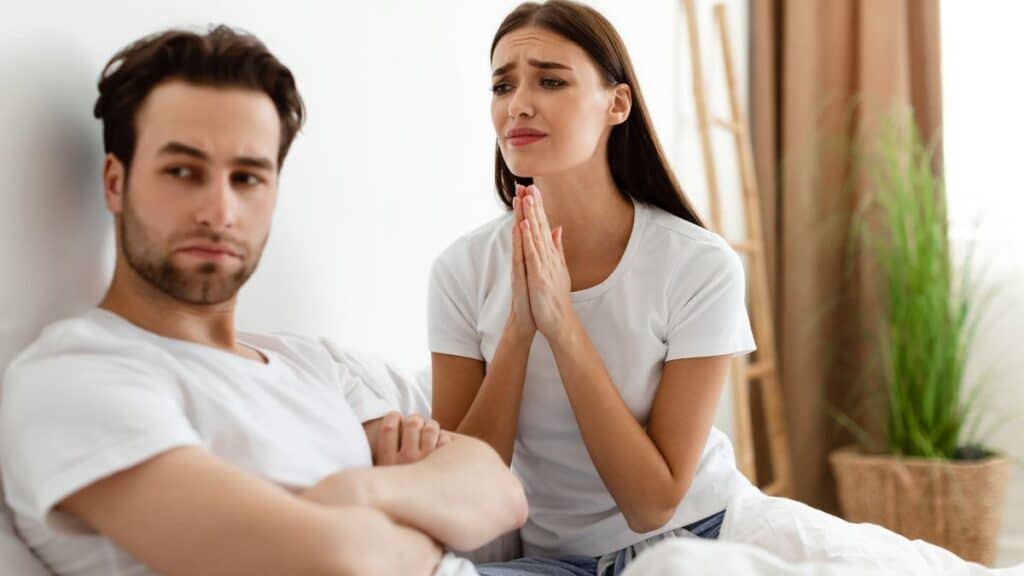 Woman pleading with her male partner to forgive her for cheating