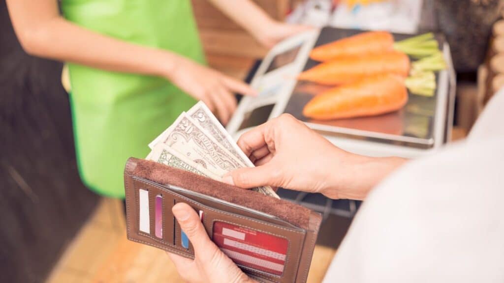 Person taking money out of their wallet to purchase food