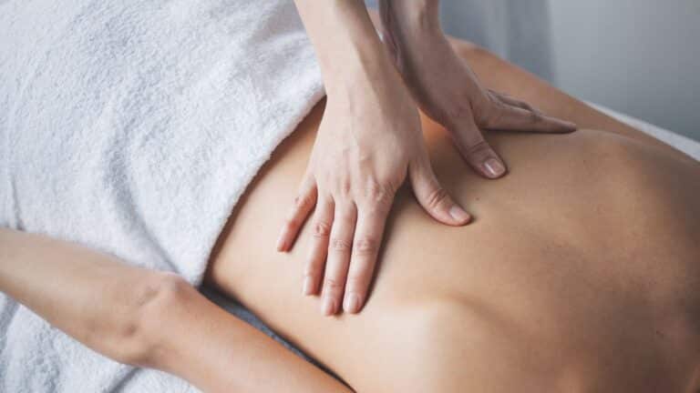 Massage therapist massaging a female's back