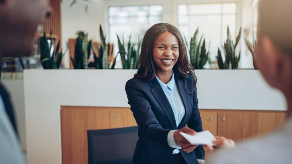 Female concierge shaking guest's hand