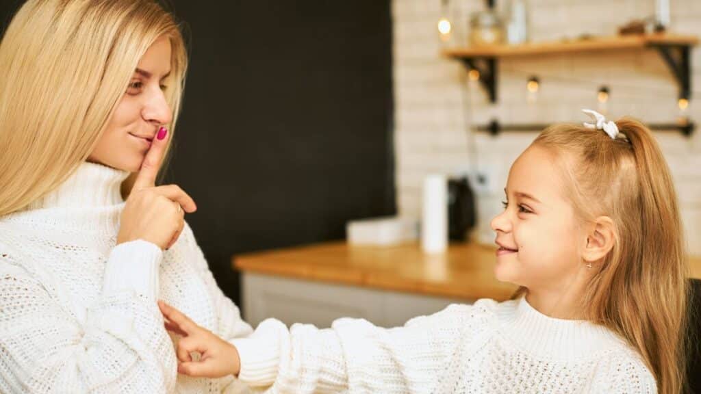 A young woman telling her child to be quiet.