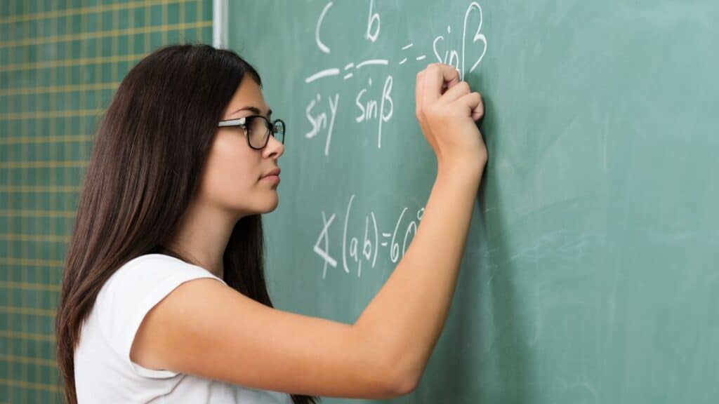 Young woman writing on a chalkboard