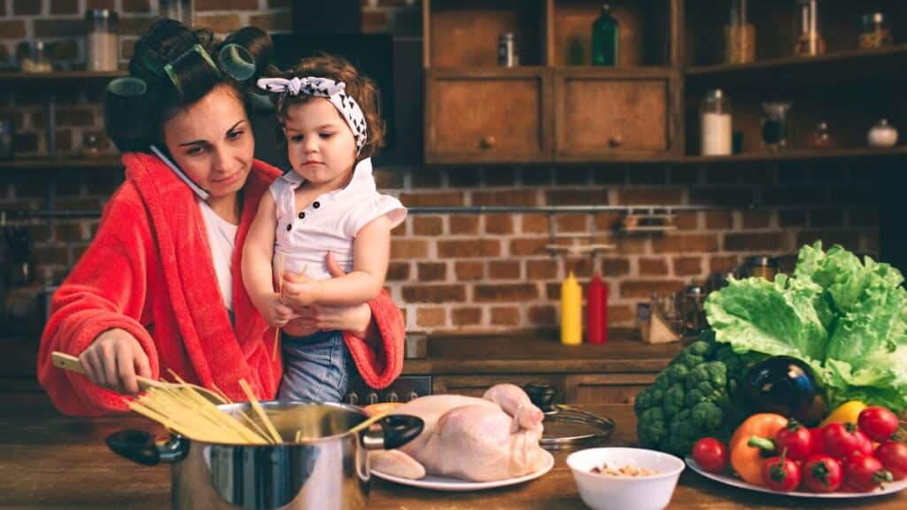 A busy mom multitasking cooking dinner and caring for her child