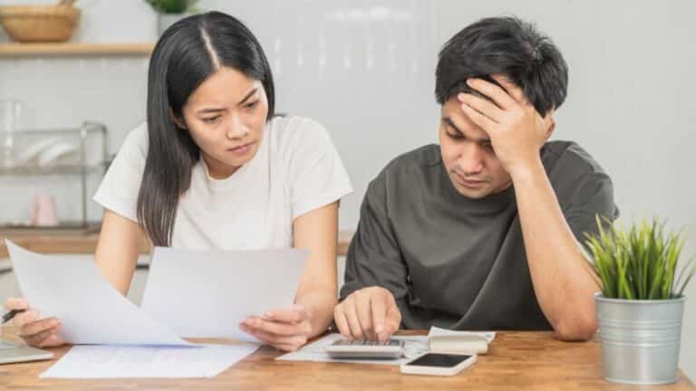 Couple looking at paperwork appearing stressed