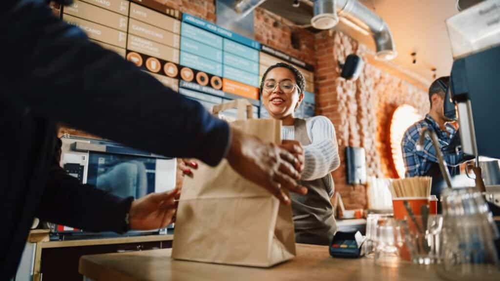 Waitress giving to go box to customer