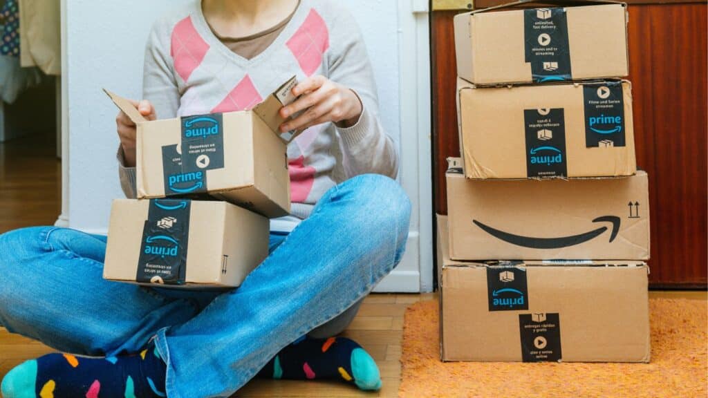 Woman sitting on the floor with a bunch of Amazon boxes