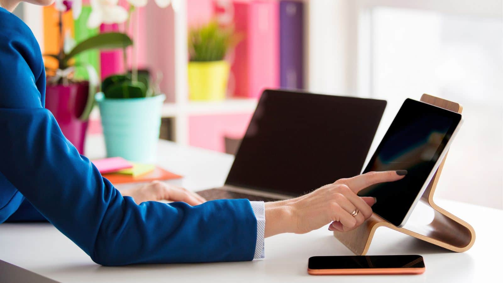 Woman using her tablets and cell phone at her desk